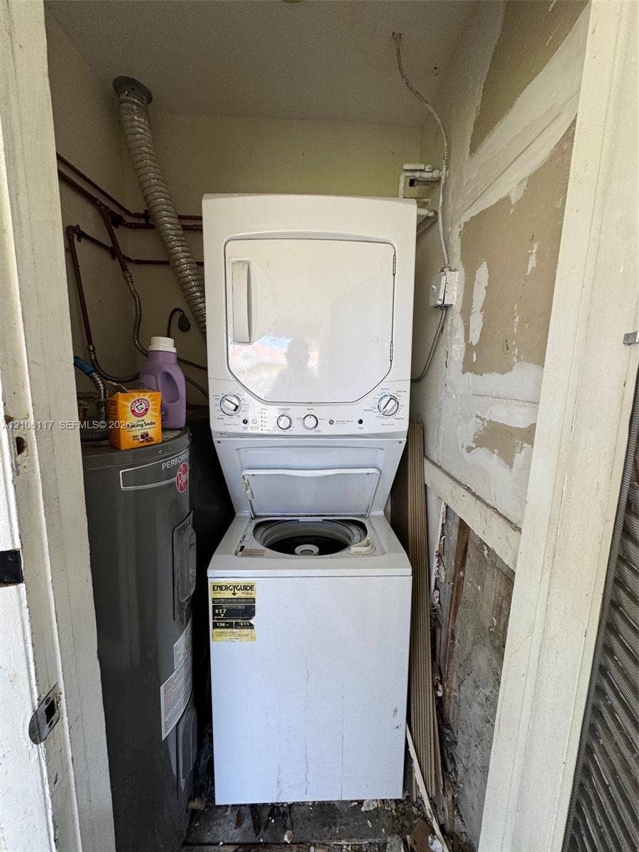 Stacked laundry unit with dryer and top-loading washer, accompanied by a dedicated water heater