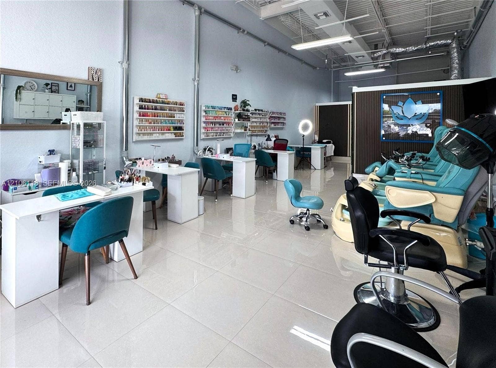 Open-concept interior featuring large-format ceramic tile flooring, exposed industrial-style ceiling ductwork, built-in wall shelving, and recessed lighting