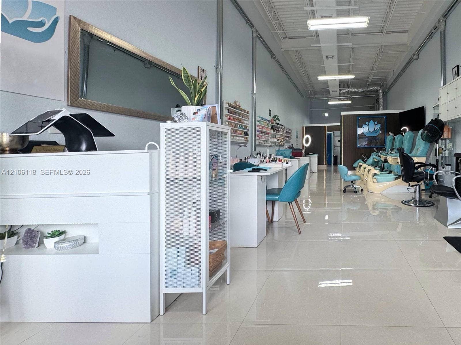 Commercial interior featuring large-format tile flooring, high exposed ceilings with linear lighting, and built-in wall shelving