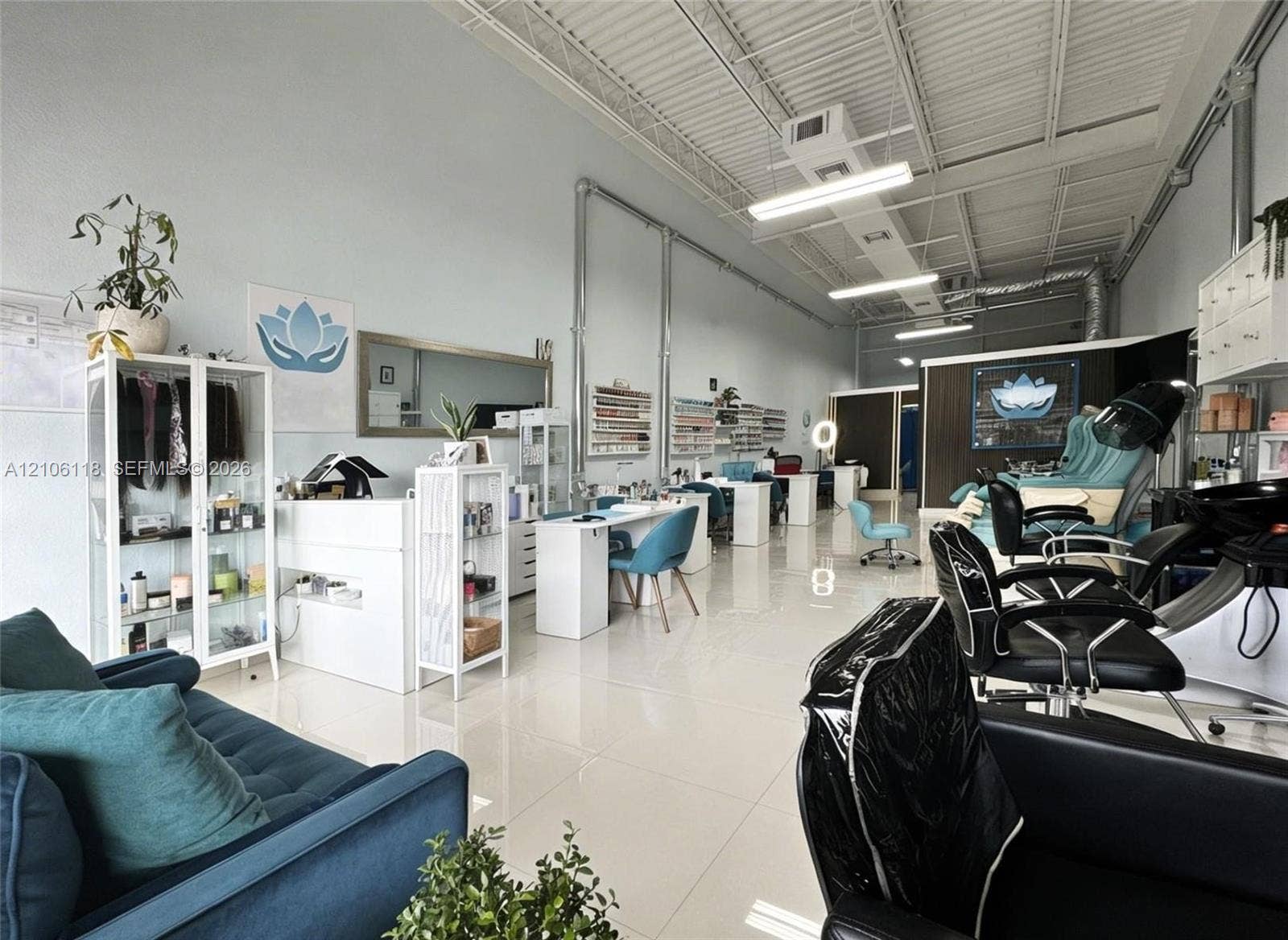 Open-concept interior featuring high ceilings with exposed ductwork, polished large-format tile flooring, and integrated wall-mounted shelving