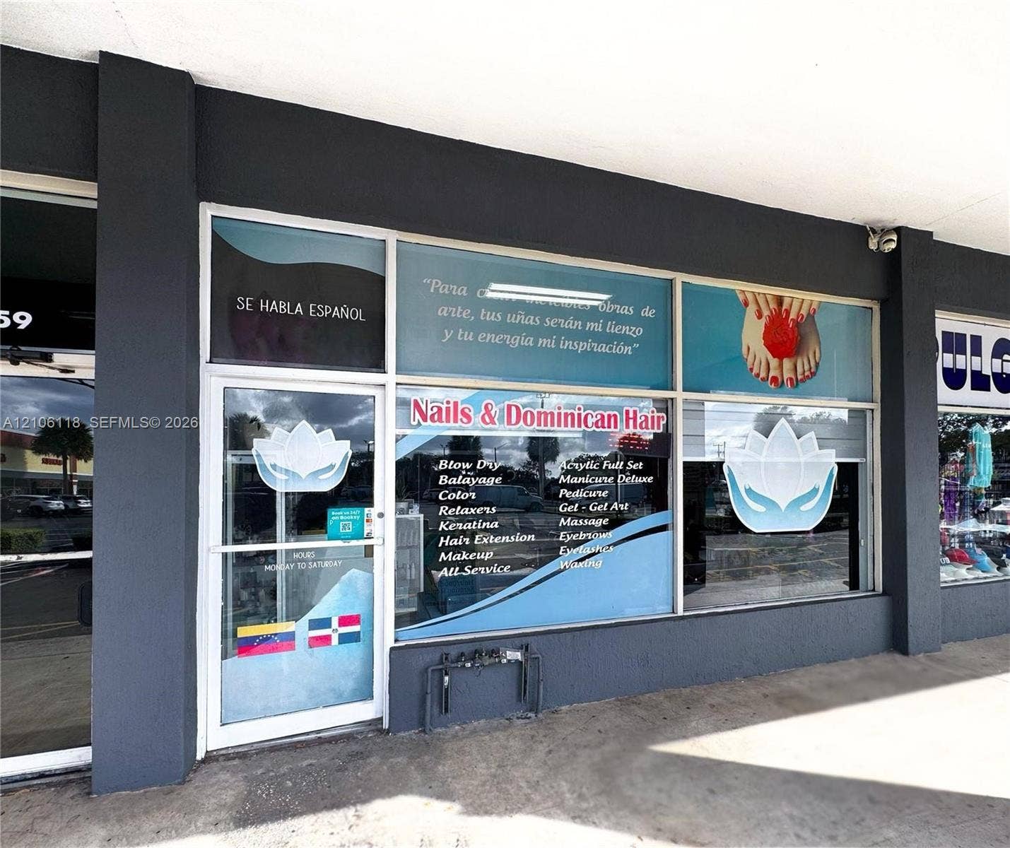 Commercial storefront featuring a glass entry door, expansive paneled windows, and dark-toned exterior masonry
