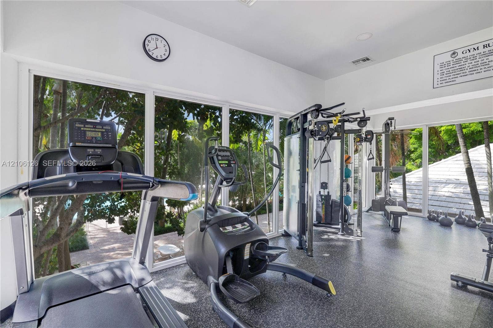 Fitness room featuring full-height floor-to-ceiling windows, recessed lighting, and durable rubber flooring