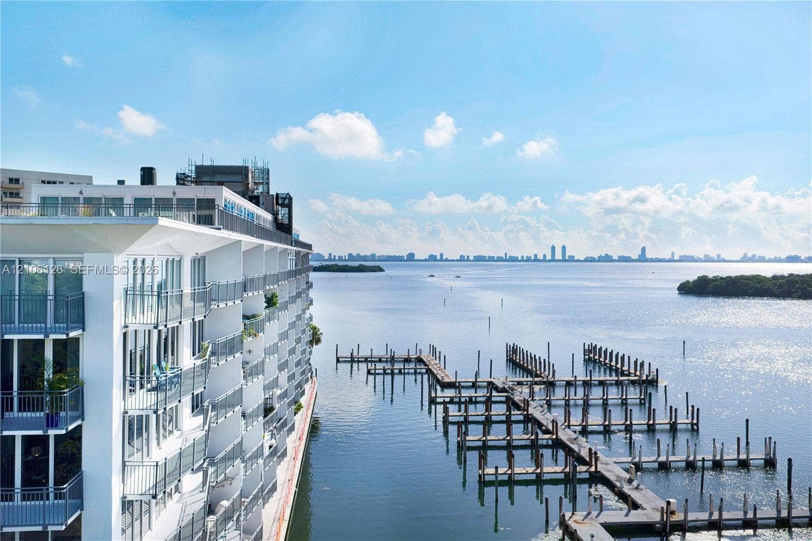 Waterfront mid-rise building featuring a multi-level boat dock and private exterior balconies