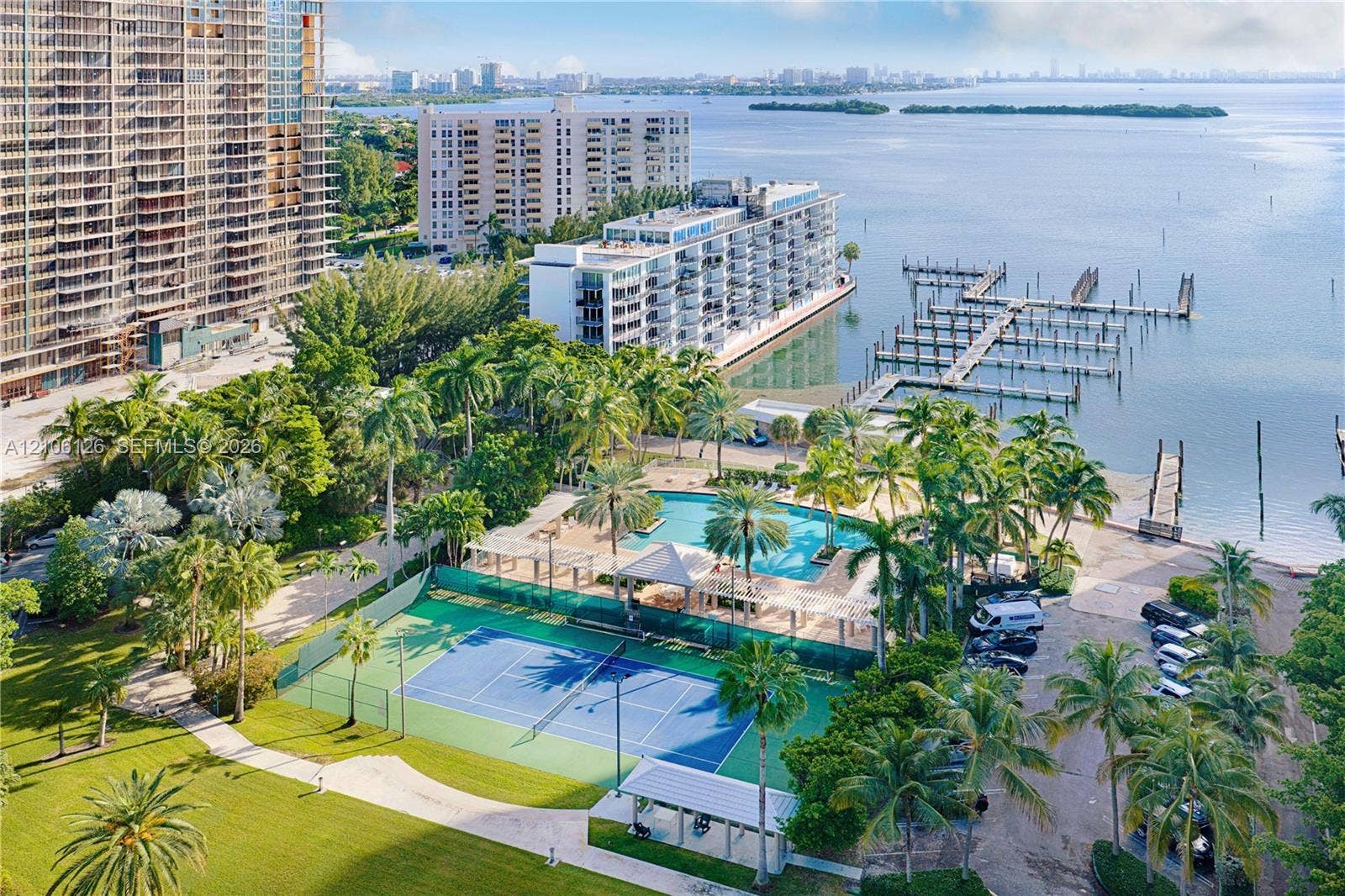 Waterfront property grounds featuring a tennis court, swimming pool, gazebo, and boat slips