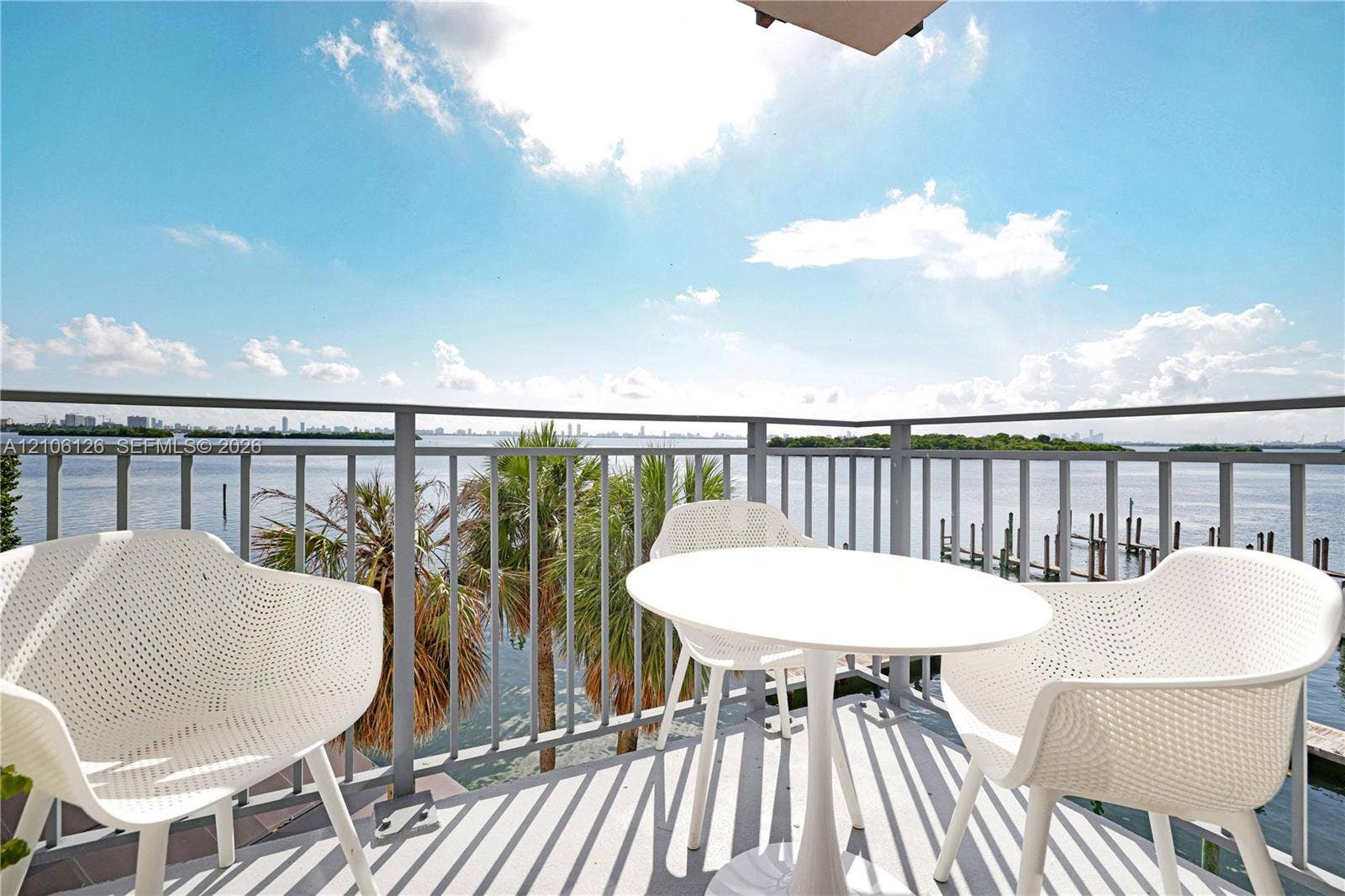 Private balcony featuring metal railings and concrete flooring, overlooking the water