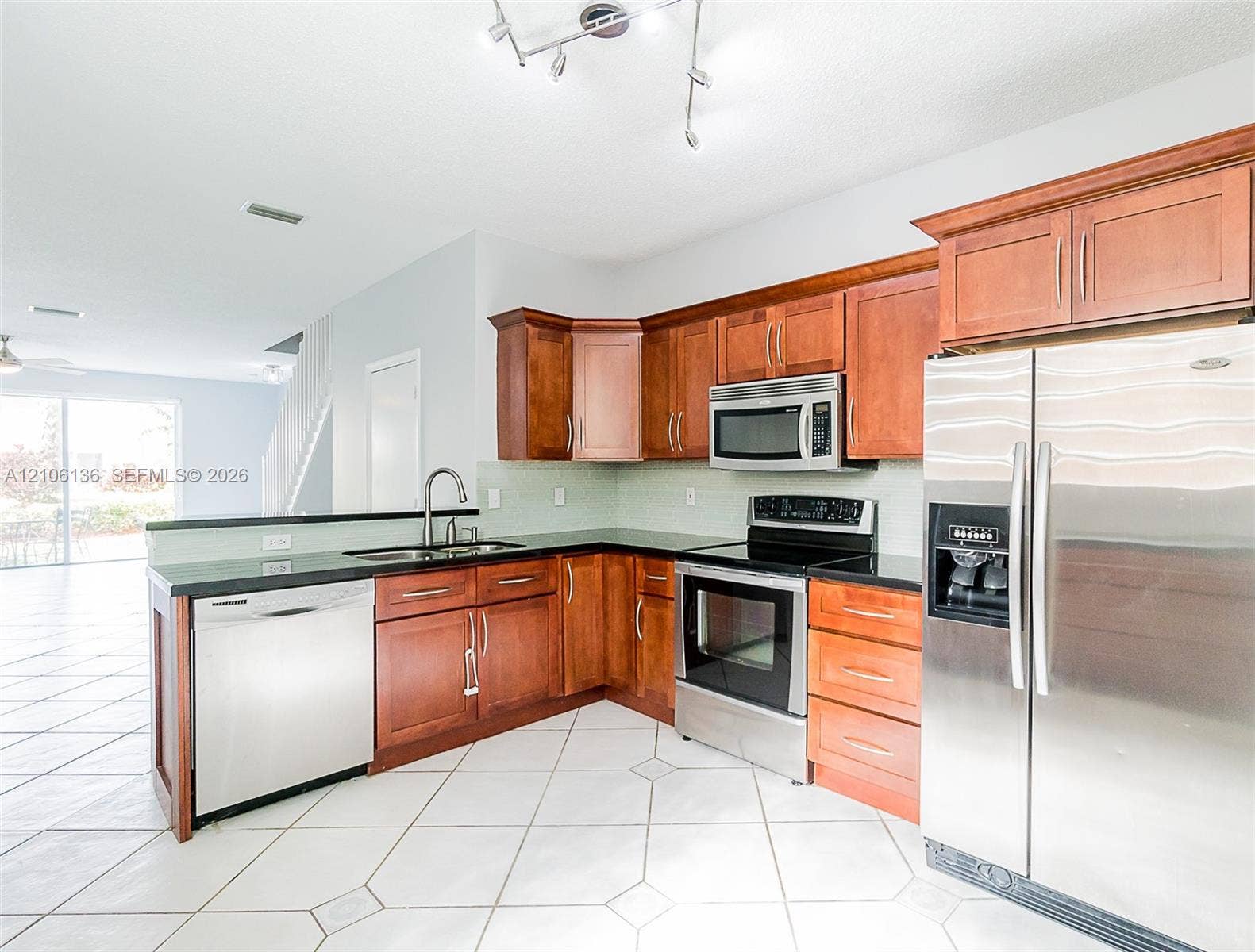 3713 San Simeon Circle, Weston, Weston, FL 33331 Kitchen featuring wood cabinetry, stainless steel appliances, dark countertops, a double-basin sink, and tile flooring