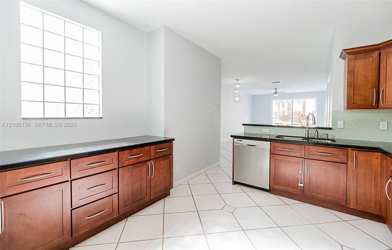3713 San Simeon Circle, Weston, Weston, FL 33331 Kitchen featuring wood cabinetry, dark stone countertops, stainless steel dishwasher, glass-block window, and tile flooring
