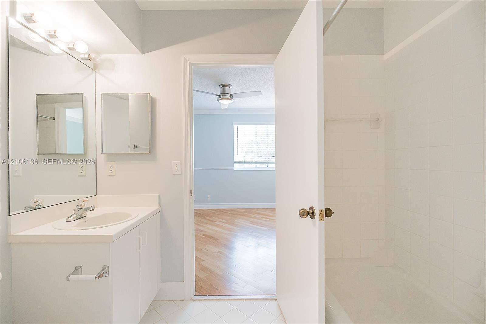 3713 San Simeon Circle, Weston, Weston, FL 33331 Bathroom featuring a white vanity cabinet with an integrated sink, large wall-mounted mirror, white ceramic tile shower surround, and tile flooring