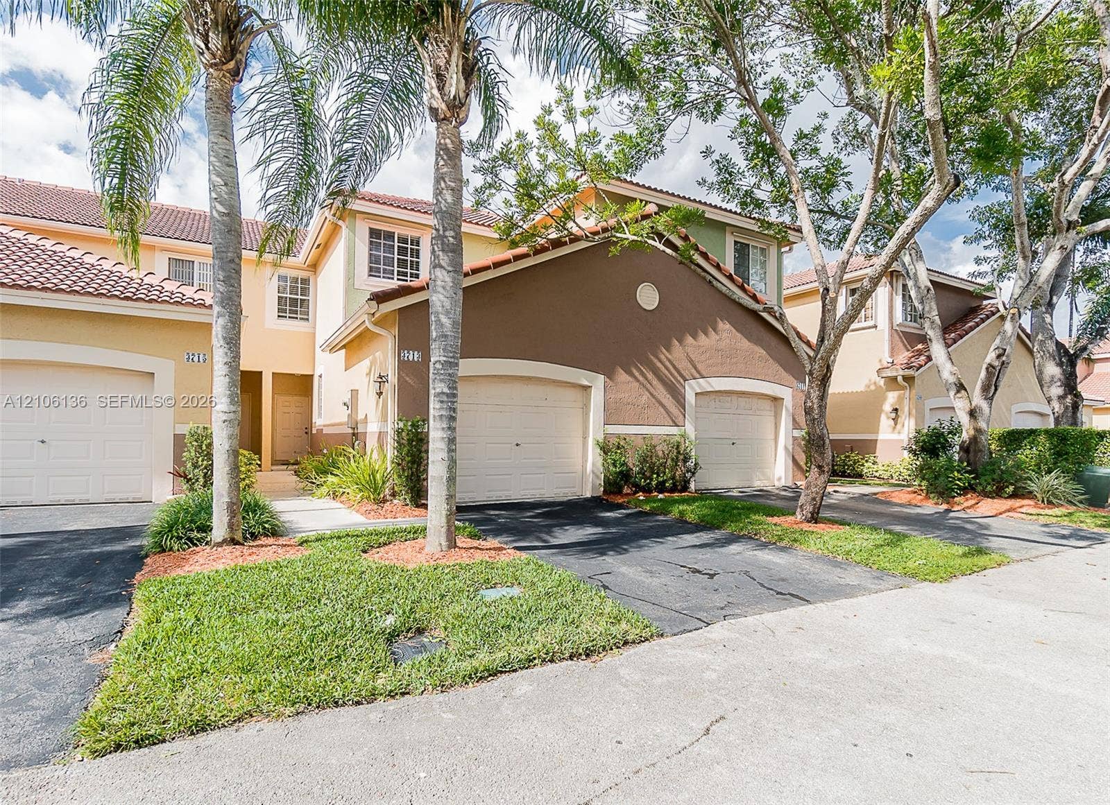 3713 San Simeon Circle, Weston, Weston, FL 33331 Stucco exterior featuring multi-toned facade, red tile roof, multi-car garage configuration, and manicured landscaping with mature palm trees