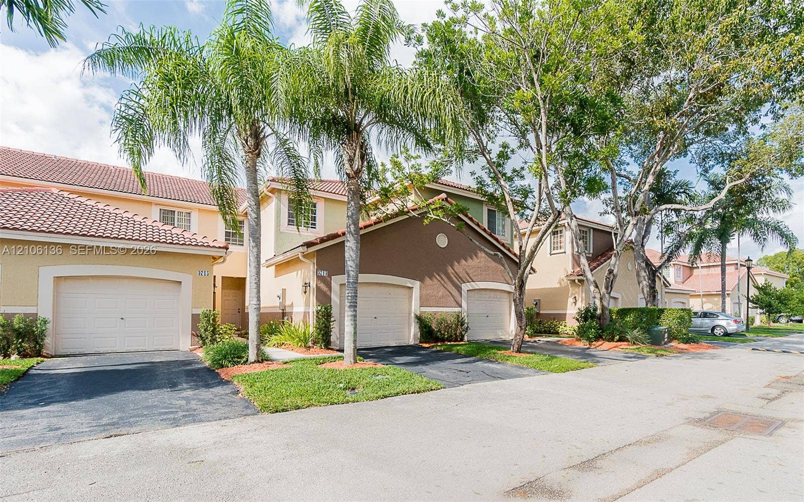 3713 San Simeon Circle, Weston, Weston, FL 33331 Multi-unit residential exterior featuring attached garages, tile roofing, stucco siding, paved driveways, and mature landscaping