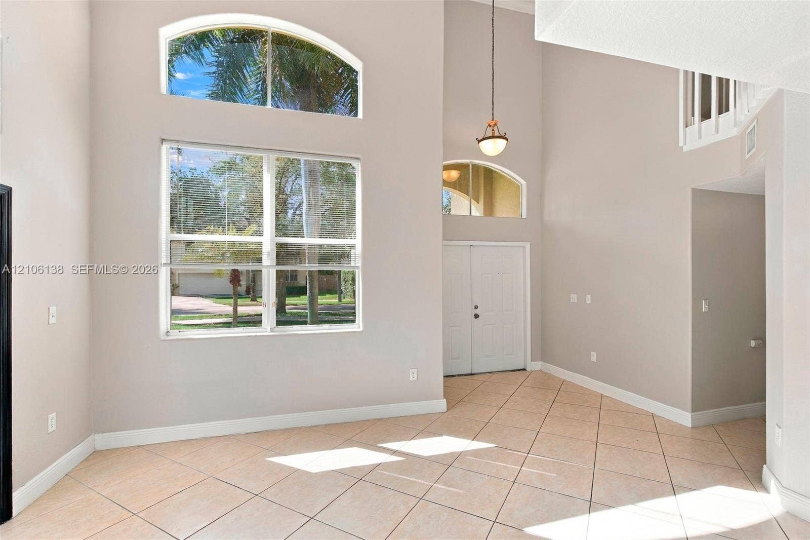 16119 SW 61st Lane, Miami, Miami, FL 33193 Double-height ceiling featuring arch-top windows, tile flooring, and a pendant light fixture