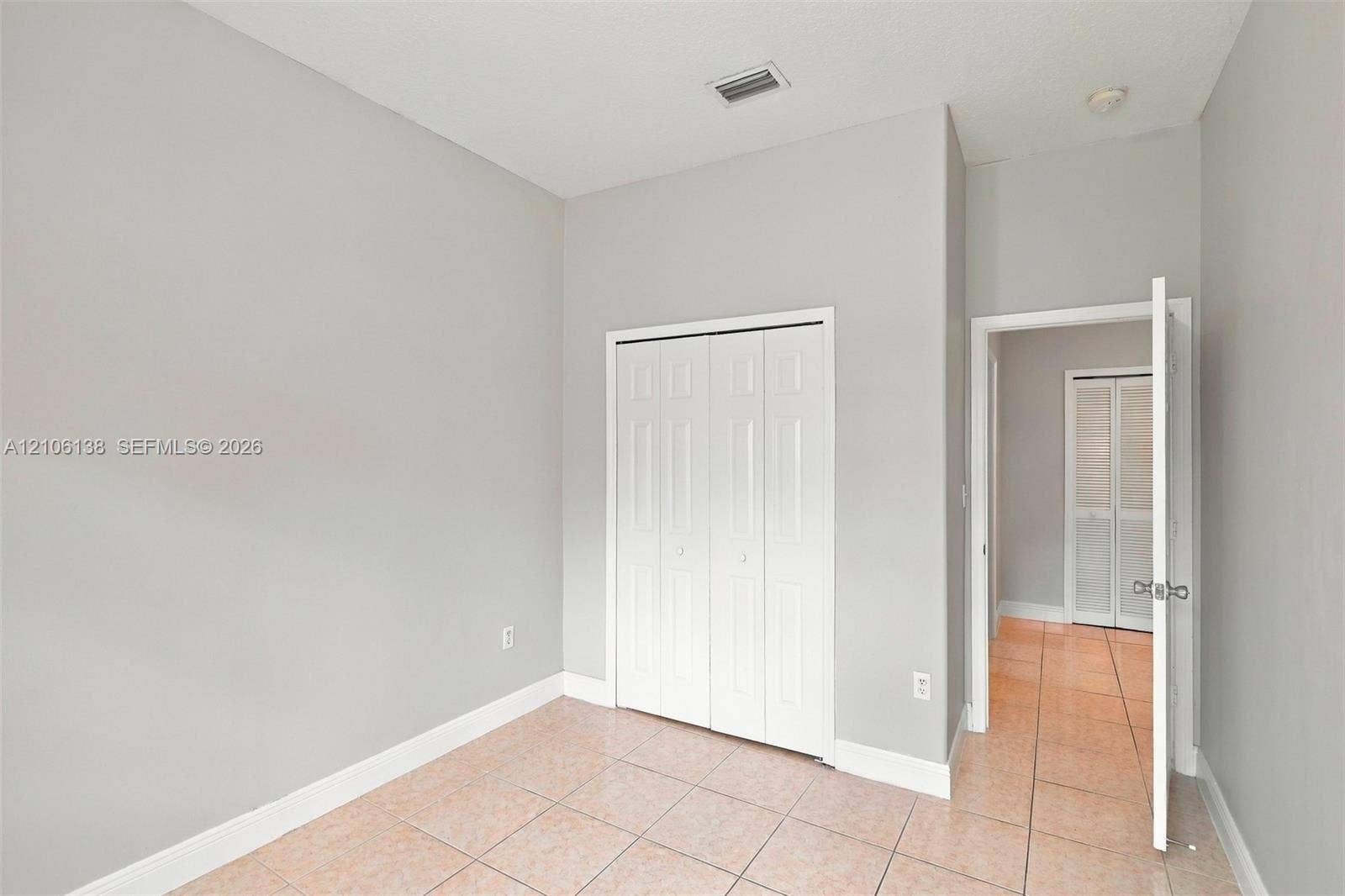 16119 SW 61st Lane, Miami, Miami, FL 33193 Neutral-toned interior space featuring light-colored tile flooring and white bi-fold closet doors