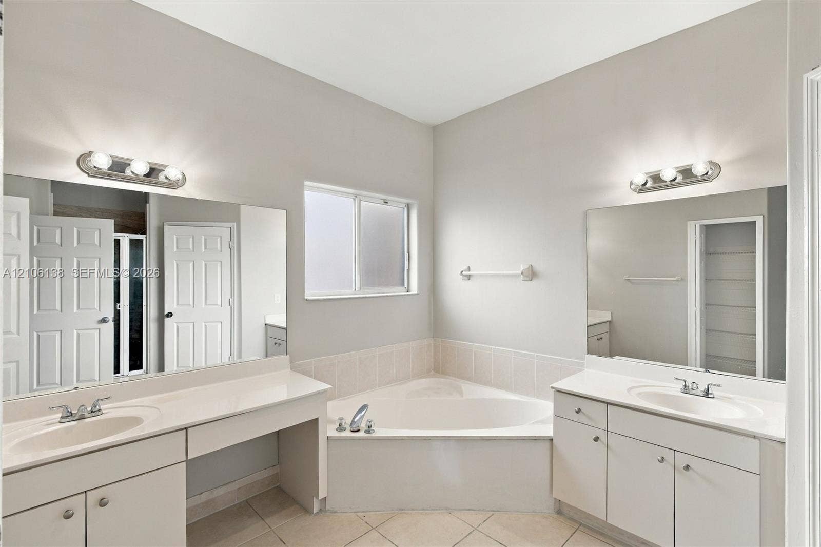 16119 SW 61st Lane, Miami, Miami, FL 33193 Dual vanities with solid-surface countertops, tile-surround soaking tub, large wall-mounted mirrors, and multi-bulb light fixtures