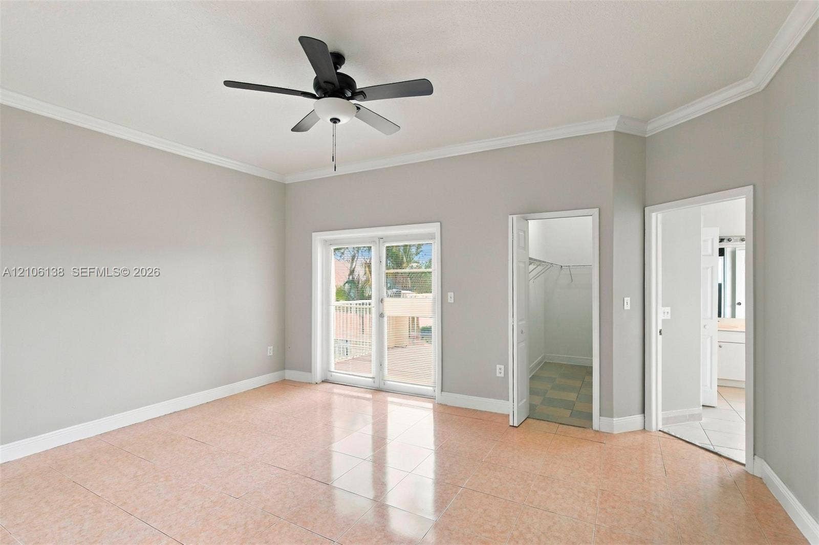 16119 SW 61st Lane, Miami, Miami, FL 33193 Neutral-toned room featuring tile flooring, crown molding, a ceiling fan with integrated light fixture, glass-paned double doors, and entryways to a walk-in closet and bathroom