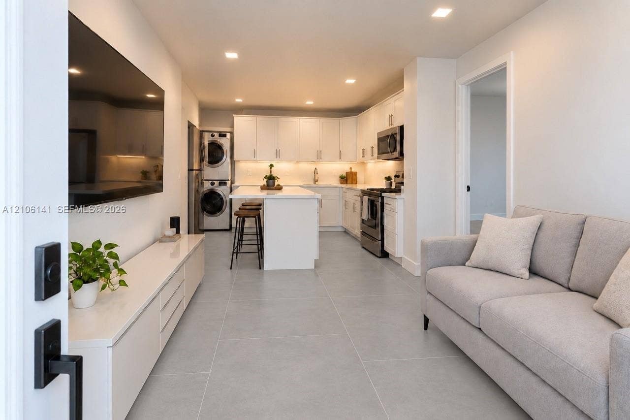 5190 E 10th Avenue, #1, Hialeah, Hialeah, FL 33013 Open-concept interior featuring large-format tile flooring, recessed lighting, white shaker-style cabinetry, stainless steel appliances, and a central kitchen island