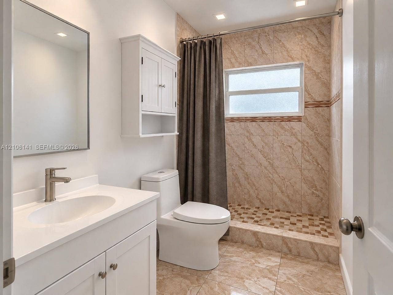5190 E 10th Avenue, #1, Hialeah, Hialeah, FL 33013 Bathroom featuring a vanity with a white countertop and undermount sink, wall-mounted medicine cabinet, walk-in shower with tiled surround and stone-finish floor, and neutral tile flooring