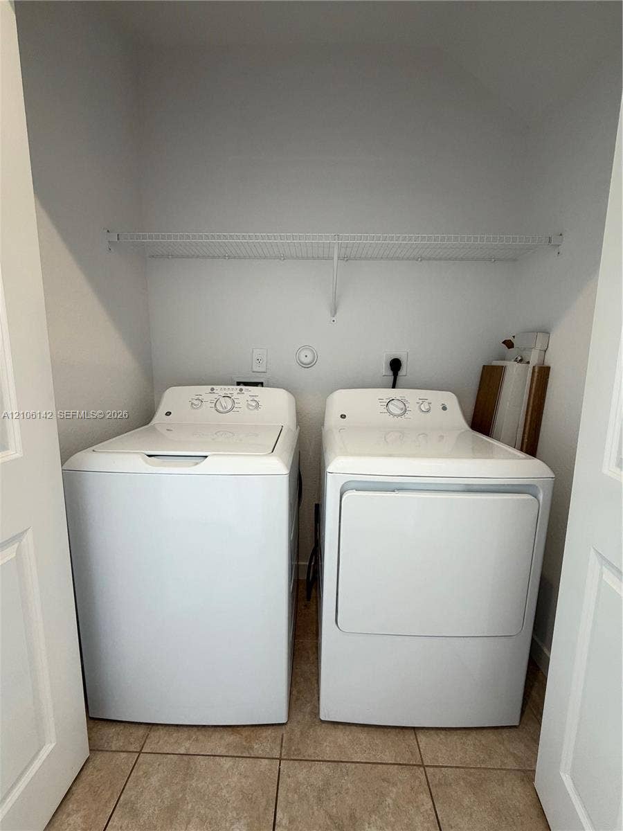 Laundry closet featuring tiled flooring and wire shelving