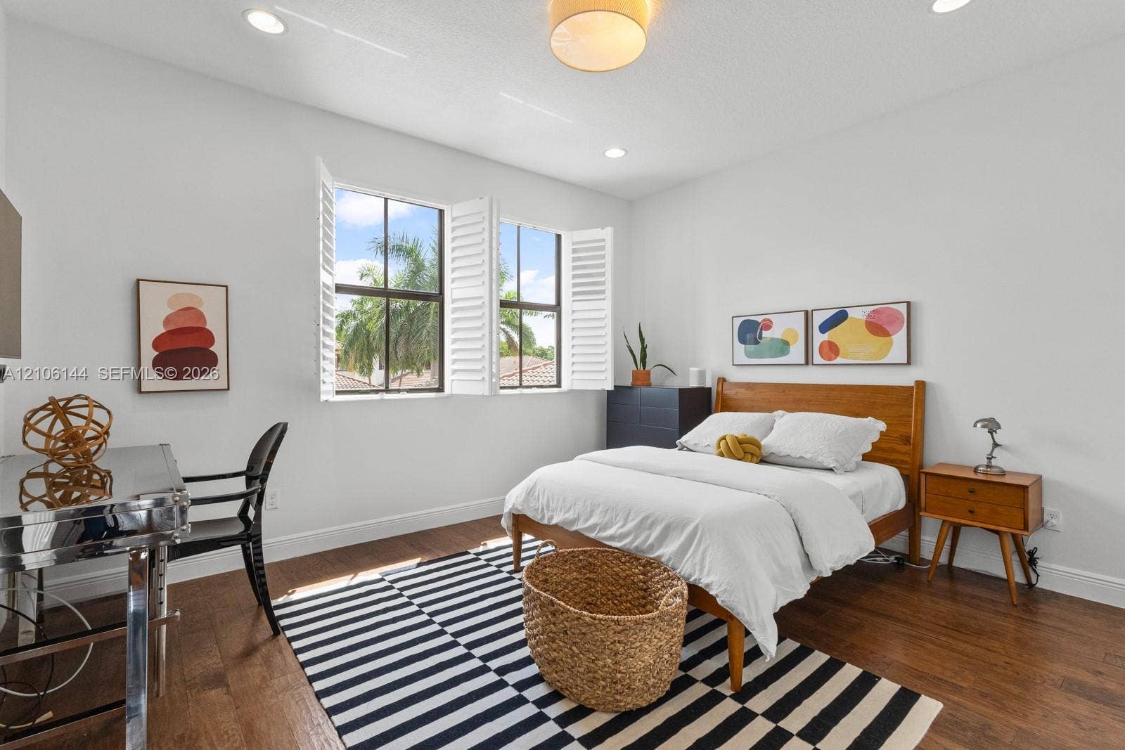 Wood-finish flooring, recessed lighting, and dual windows featuring white plantation shutters