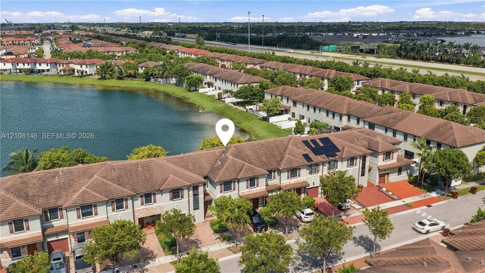 3259 W 100th Terrace, Hialeah, FL 33018 Multi-level townhome featuring a tiled roof, paver driveway, and waterfront positioning