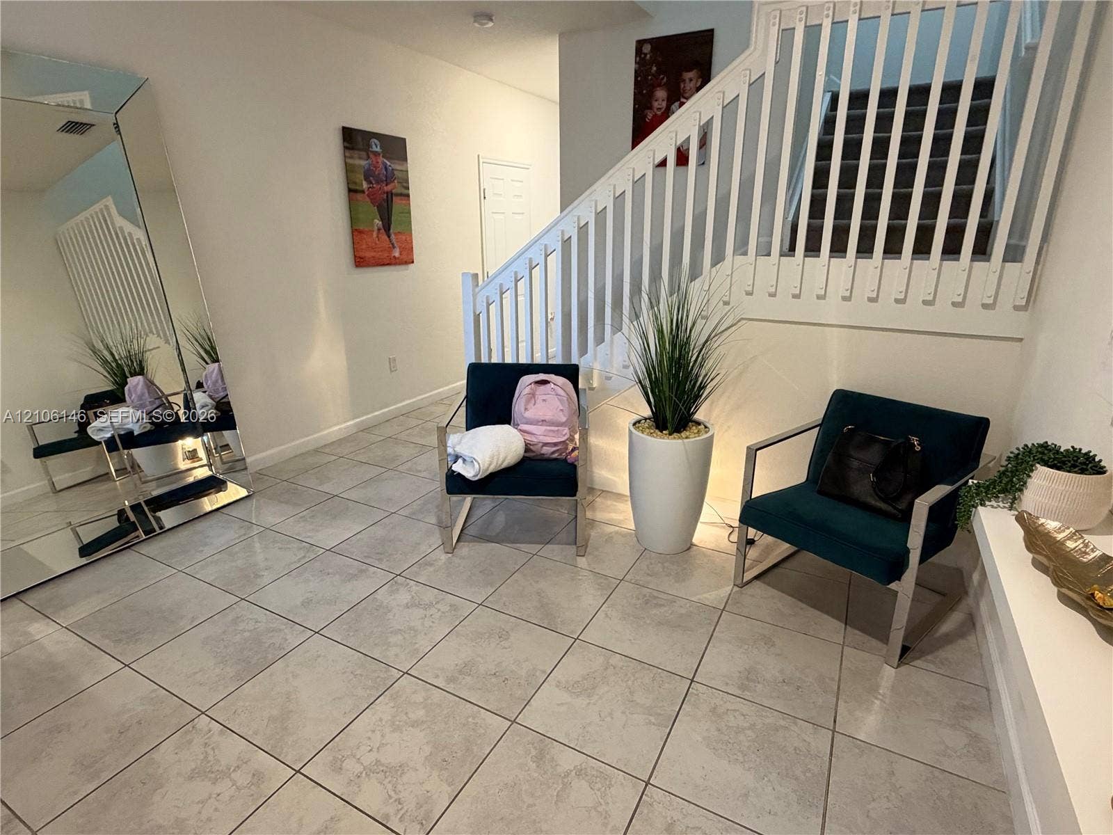 3259 W 100th Terrace, Hialeah, FL 33018 Neutral tile flooring, staircase with white wooden balusters, and a wall-mounted flush-mount light fixture