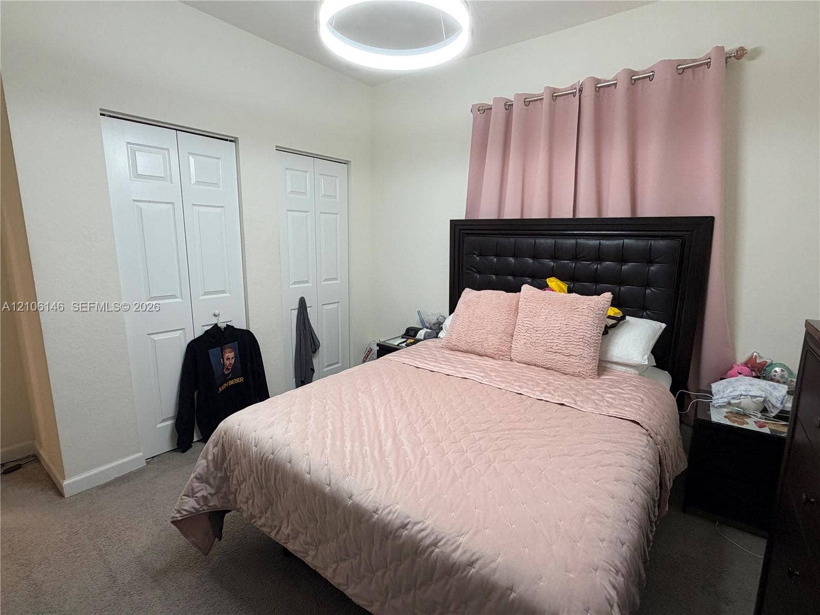 3259 W 100th Terrace, Hialeah, FL 33018 Neutral wall color, wall-to-wall carpeting, dual white panel doors for closet storage, and a modern circular LED flush-mount ceiling fixture
