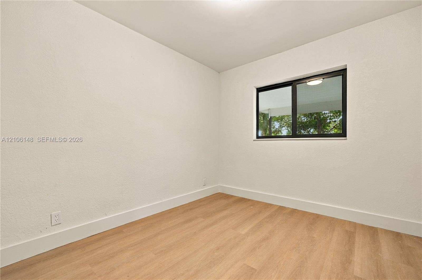 2920 Dorson Way, Delray Beach, FL 33445 Room featuring neutral walls, light-toned wood-finish flooring, and a sliding window with a dark frame