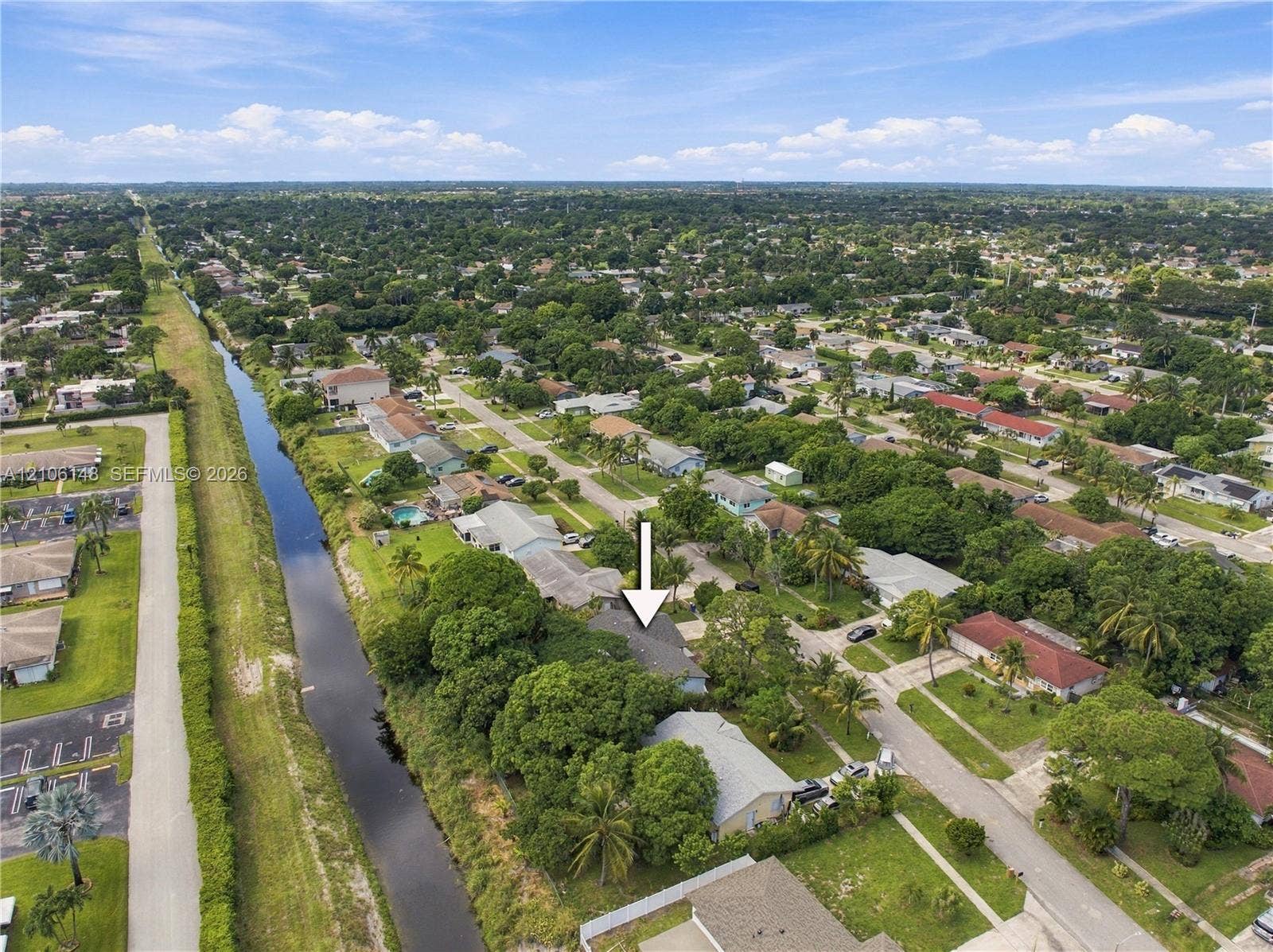 2920 Dorson Way, Delray Beach, FL 33445 Aerial perspective of a property featuring mature perimeter trees, a canal-front position, and established neighborhood landscaping