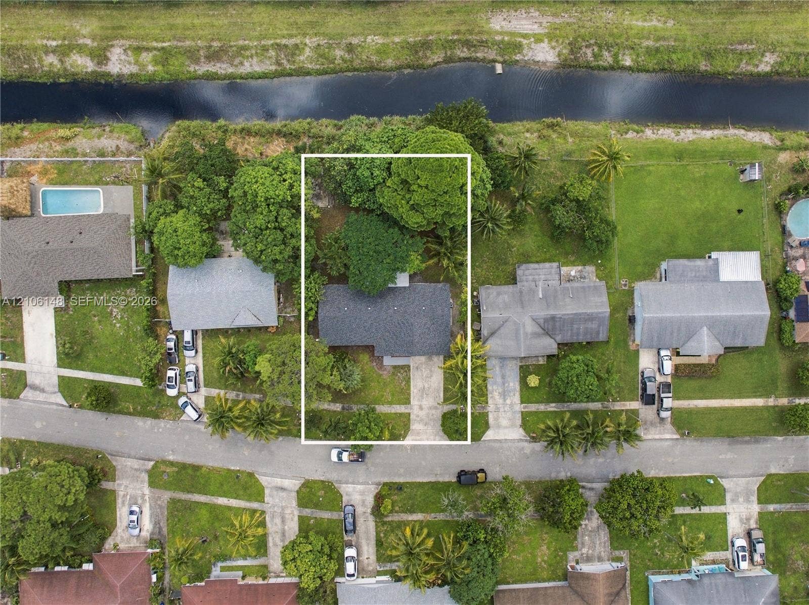 2920 Dorson Way, Delray Beach, FL 33445 Aerial perspective of residential property featuring a composition shingle roof, concrete driveway, and mature landscaping