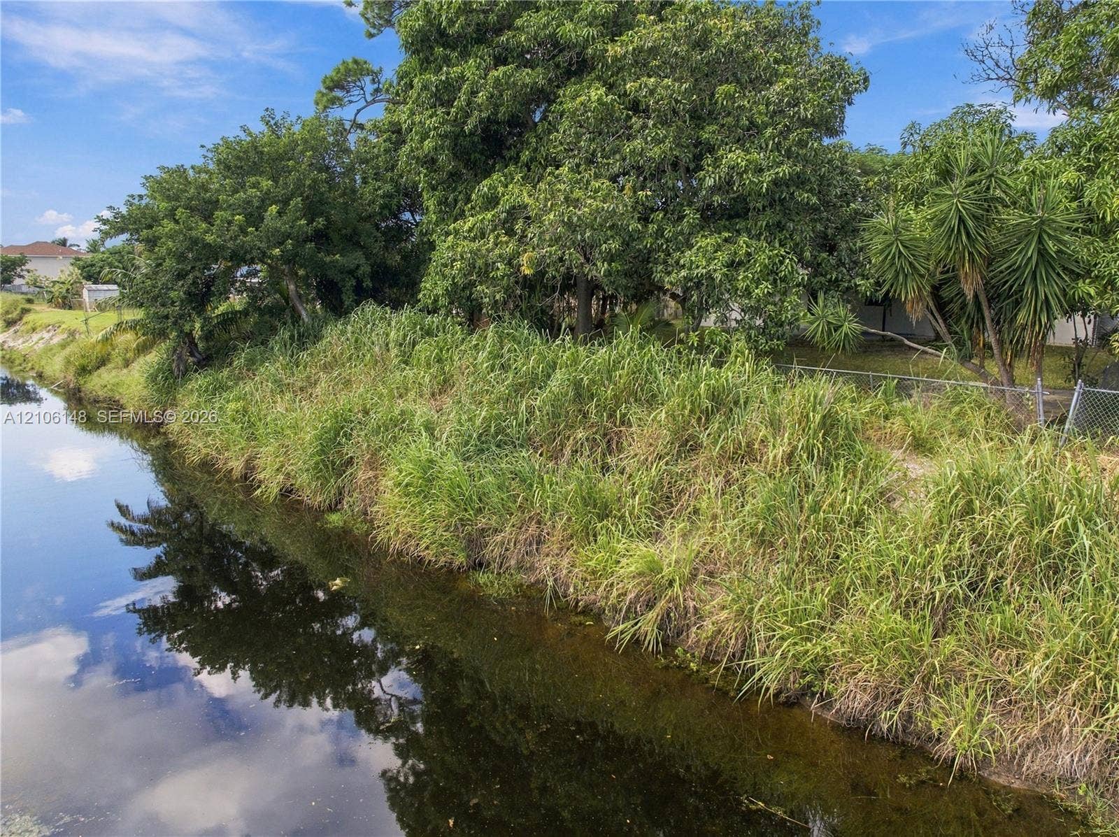 2920 Dorson Way, Delray Beach, FL 33445 Waterfront parcel featuring a natural canal border, mature trees, and native vegetation