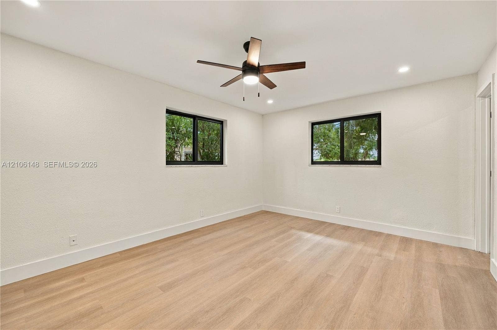 2920 Dorson Way, Delray Beach, FL 33445 Neutral interior space featuring wood-finish flooring, recessed lighting, a ceiling fan with integrated lighting, and dual windows with black frames