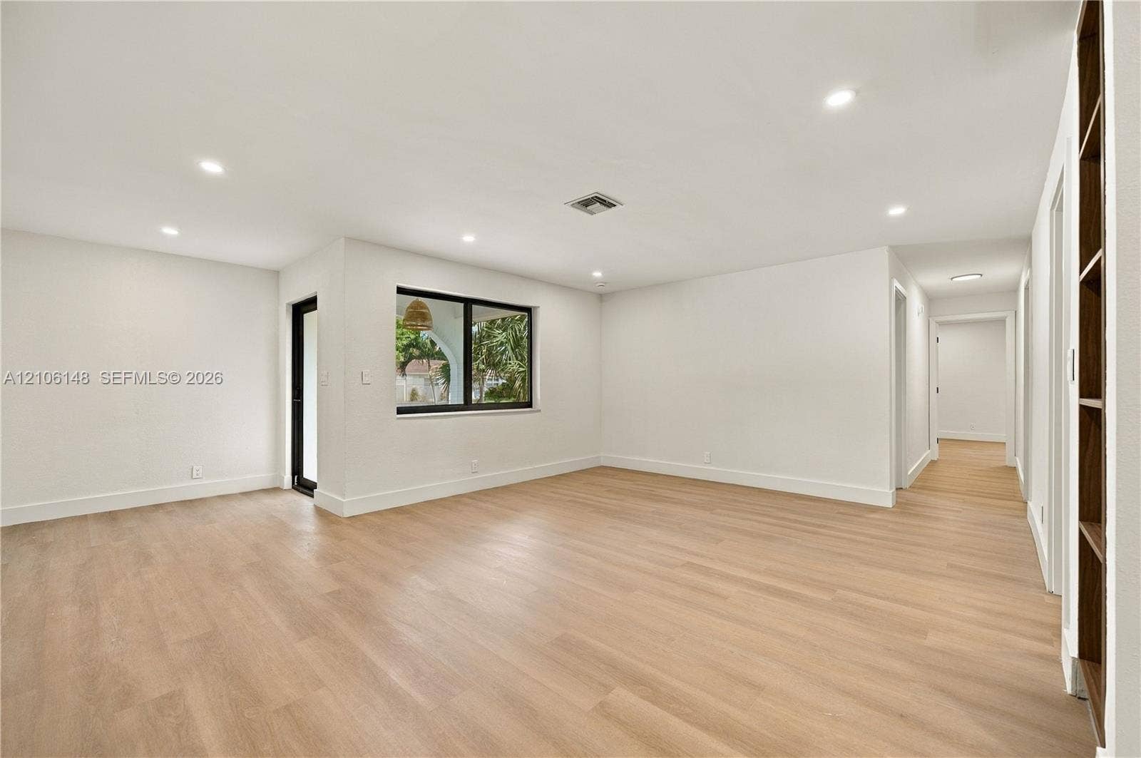 2920 Dorson Way, Delray Beach, FL 33445 Neutral interior featuring wood-finish flooring, recessed lighting, a built-in wooden shelving unit, and a black-framed window