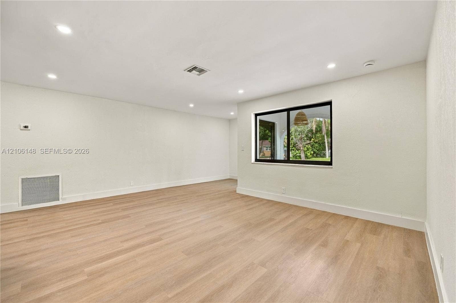 2920 Dorson Way, Delray Beach, FL 33445 Interior space featuring wood-finish flooring, recessed lighting, and a large window with black framing