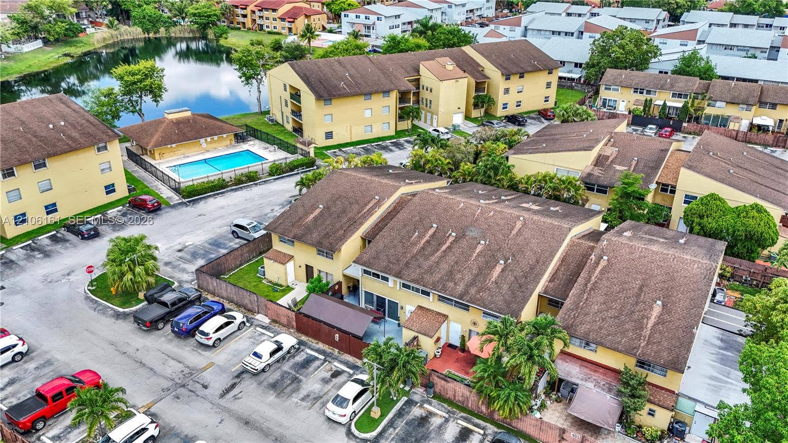 15460 SW 82nd Lane, #403, Miami, Miami, FL 33193 Aerial perspective featuring multi-story residential buildings, paved surface parking, and a community swimming pool