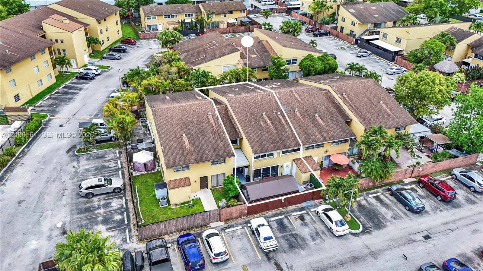 15460 SW 82nd Lane, #403, Miami, Miami, FL 33193 Two-story multi-family residence featuring a shingled roof, stucco exterior, fenced private patio area, and dedicated surface parking