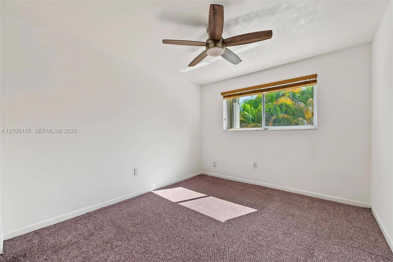 7205 W 3rd Avenue, #1, Hialeah, Hialeah, FL 33014 Neutral interior room featuring wall-to-wall carpeting, a multi-blade ceiling fan with a wood finish, and a sliding window with horizontal window blinds