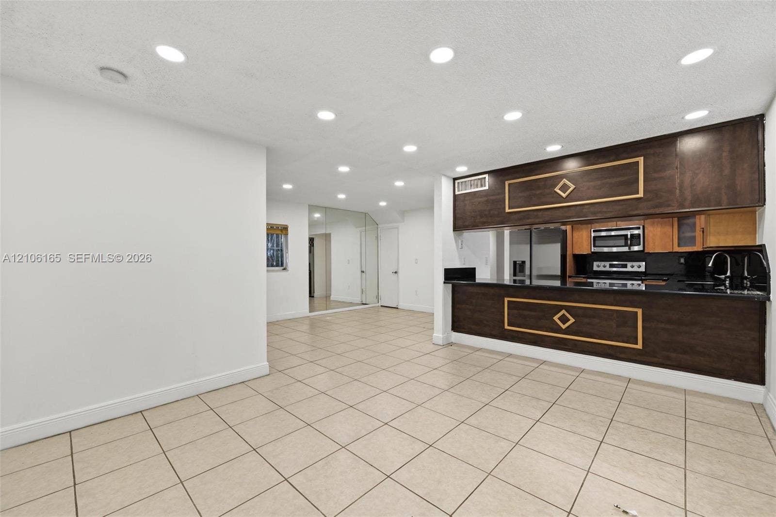 7205 W 3rd Avenue, #1, Hialeah, Hialeah, FL 33014 Kitchen featuring recessed lighting, tile flooring, dark wood-finish cabinetry, built-in stainless steel appliances, and a polished stone countertop