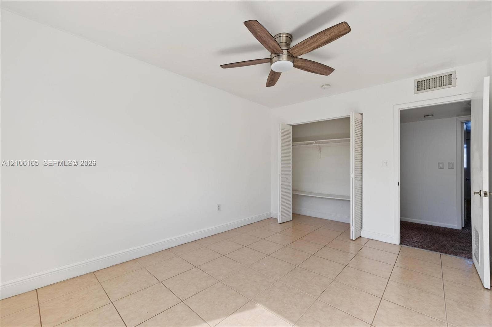 7205 W 3rd Avenue, #1, Hialeah, Hialeah, FL 33014 Room featuring tile flooring, a six-blade ceiling fan with integrated lighting, and a reach-in closet with bi-fold doors
