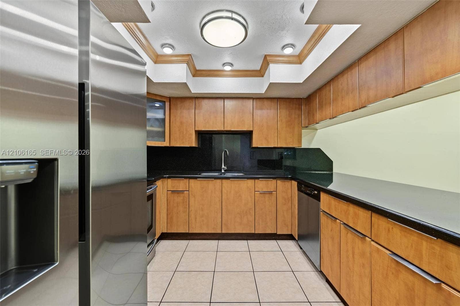 7205 W 3rd Avenue, #1, Hialeah, Hialeah, FL 33014 Kitchen featuring wood-finish cabinetry, solid surface countertops, stainless steel appliances, a tray ceiling with recessed lighting, and tile flooring