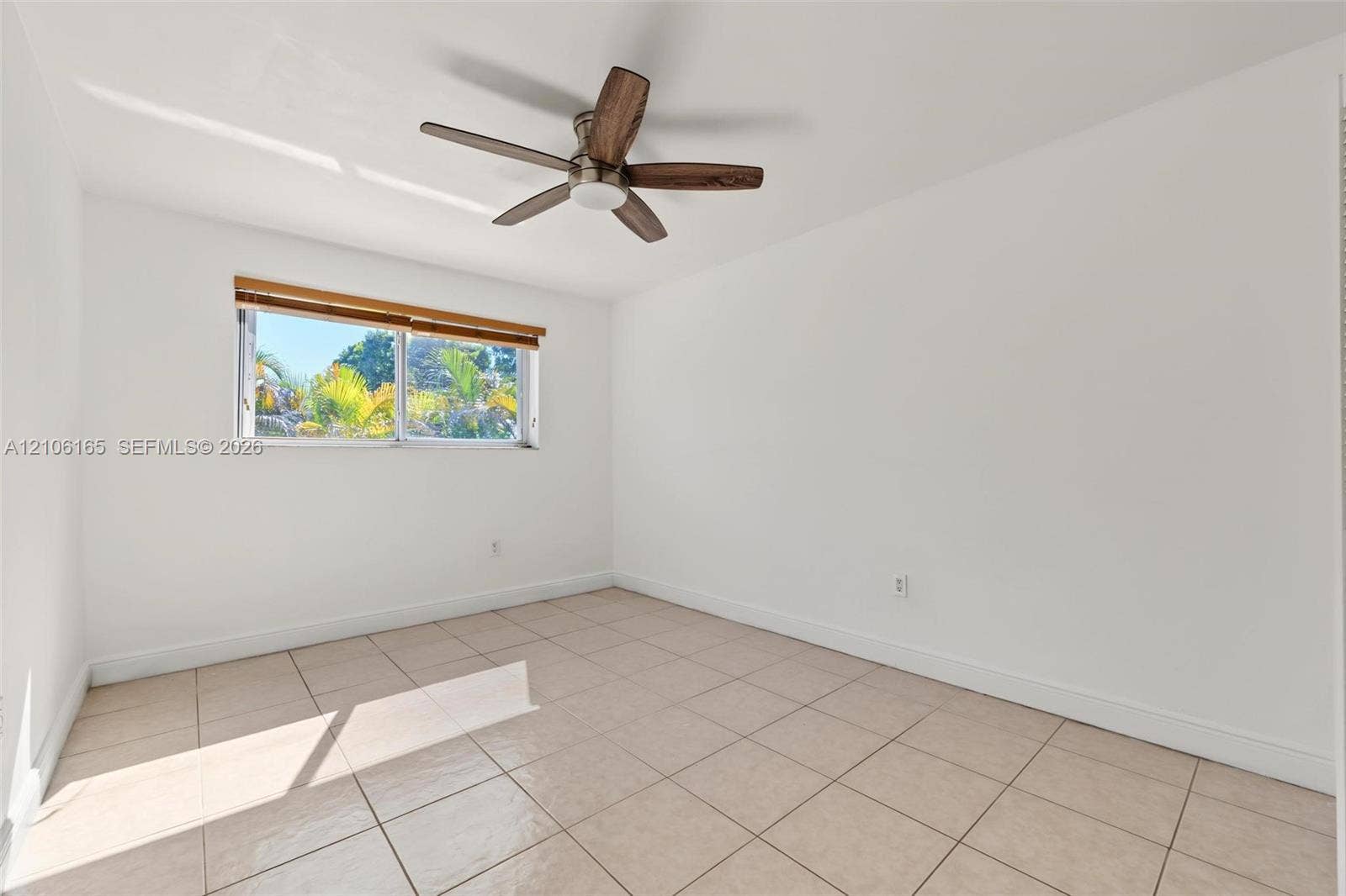 7205 W 3rd Avenue, #1, Hialeah, Hialeah, FL 33014 Neutral wall finishes, tile flooring, sliding window with wood-finish trim, and ceiling fan with wood-finish blades