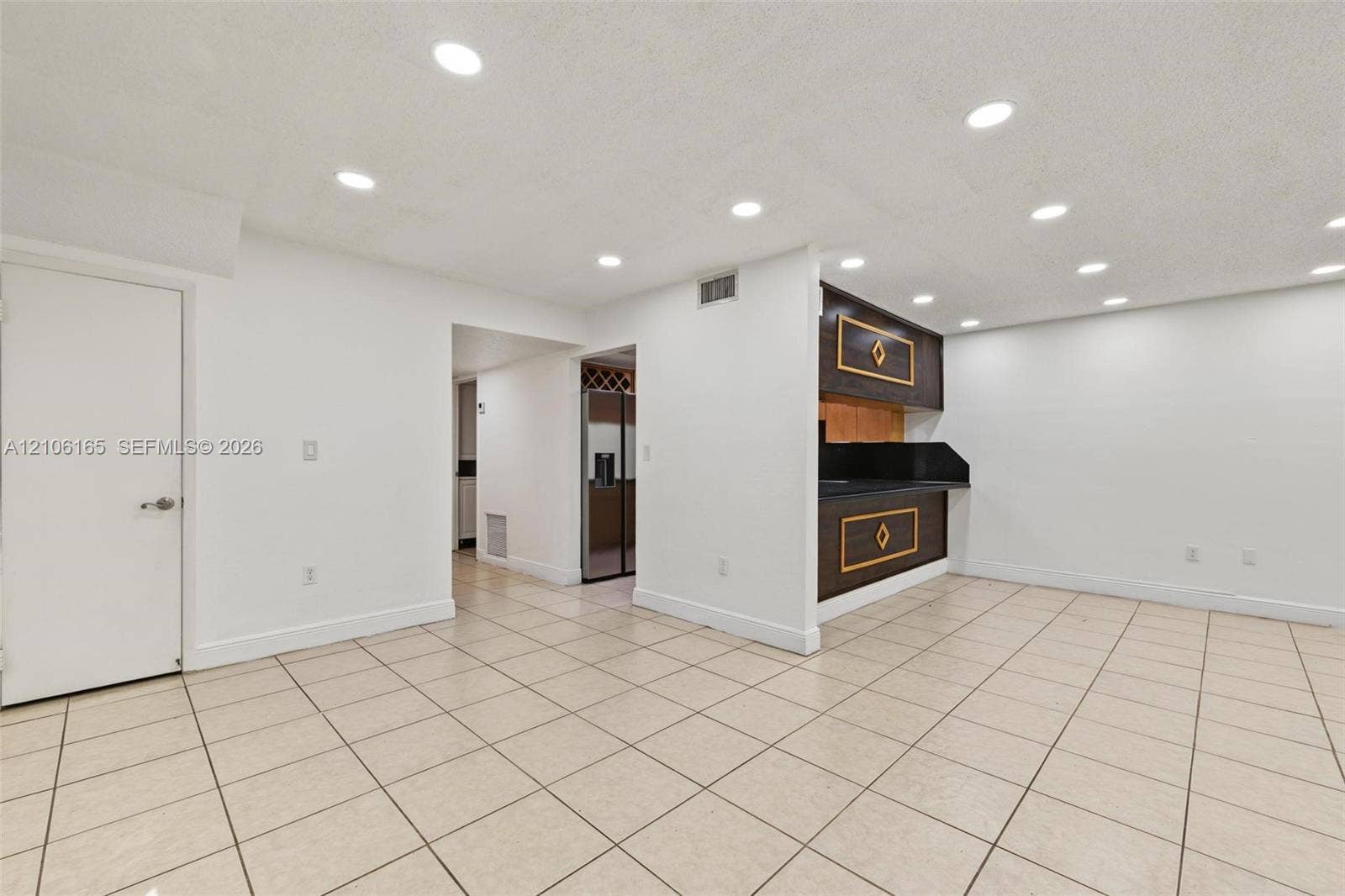 7205 W 3rd Avenue, #1, Hialeah, Hialeah, FL 33014 Tile flooring, recessed lighting, and a built-in wet bar featuring dark cabinetry with decorative trim and a solid-surface countertop