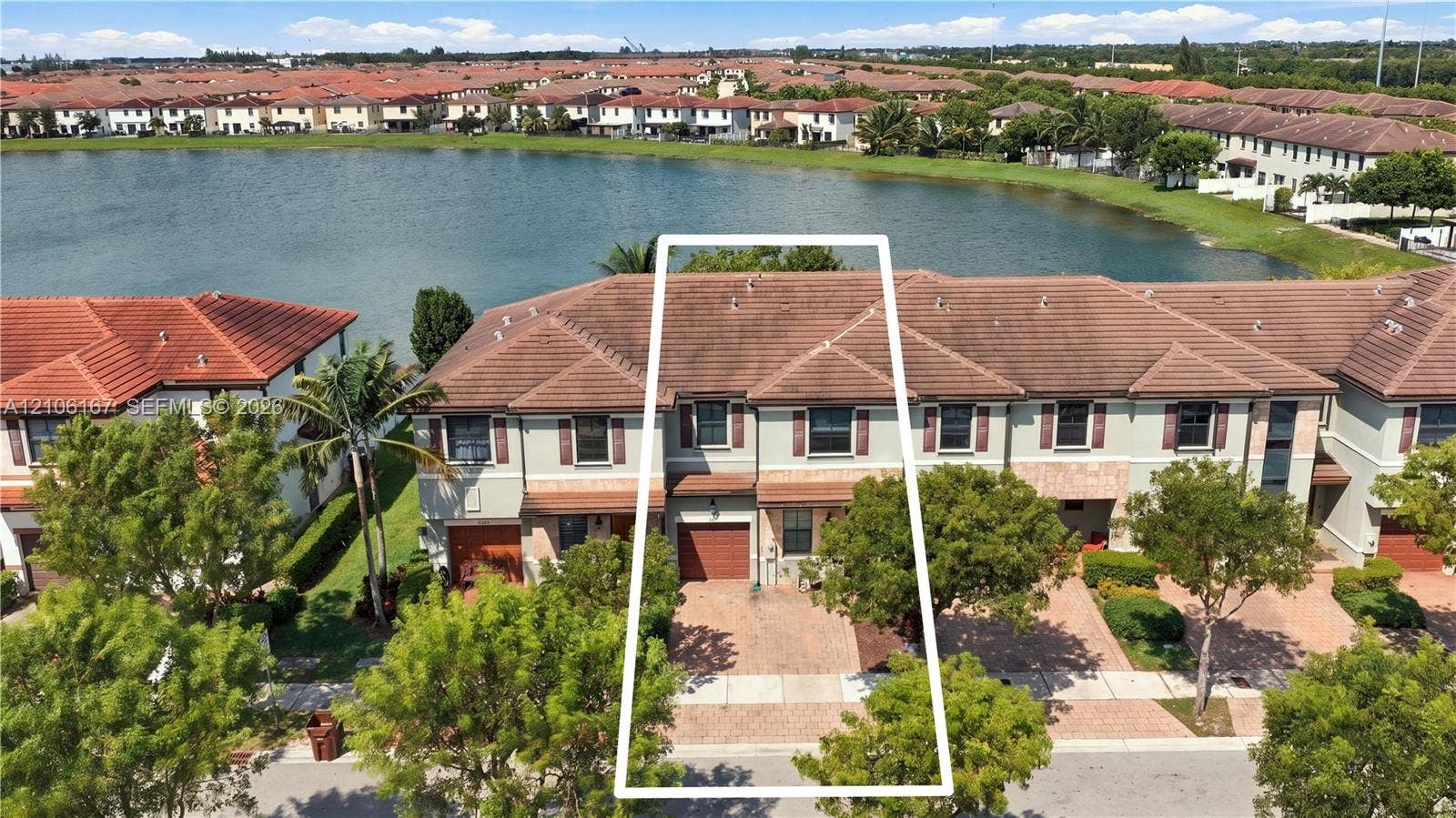3277 W 100th Terrace, Hialeah, FL 33018 Two-story residence featuring a tile roof, brick-paver driveway, and an attached single-car garage