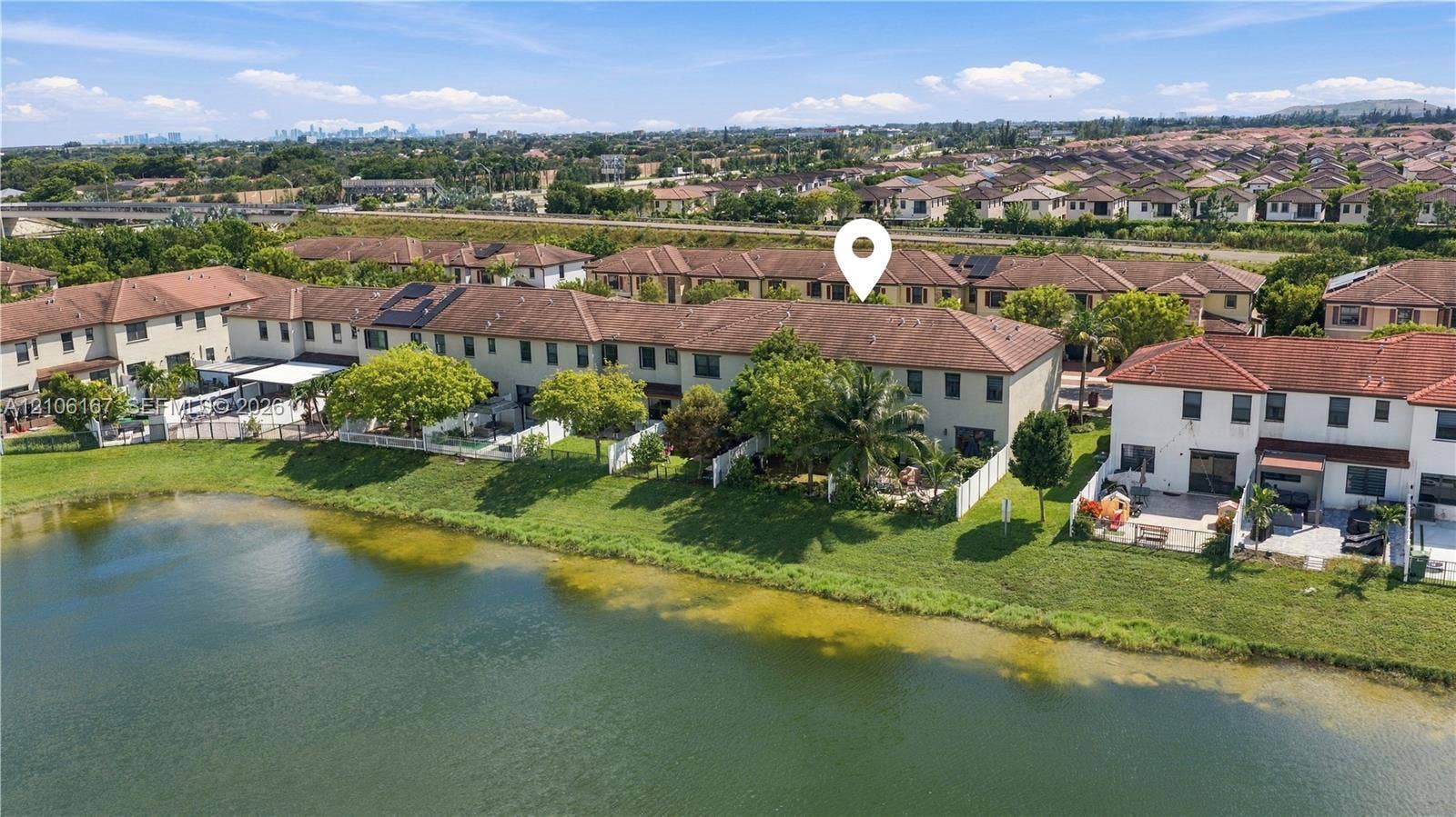 3277 W 100th Terrace, Hialeah, FL 33018 Two-story exterior featuring a tile roof and water-front placement with direct pond access