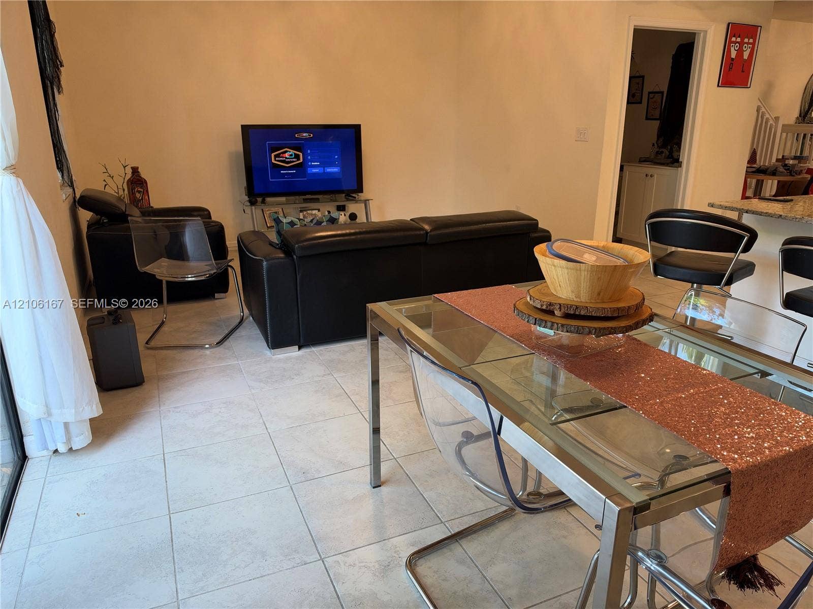 3277 W 100th Terrace, Hialeah, FL 33018 Open-concept interior featuring light-toned tile flooring and a kitchen breakfast bar with granite countertop