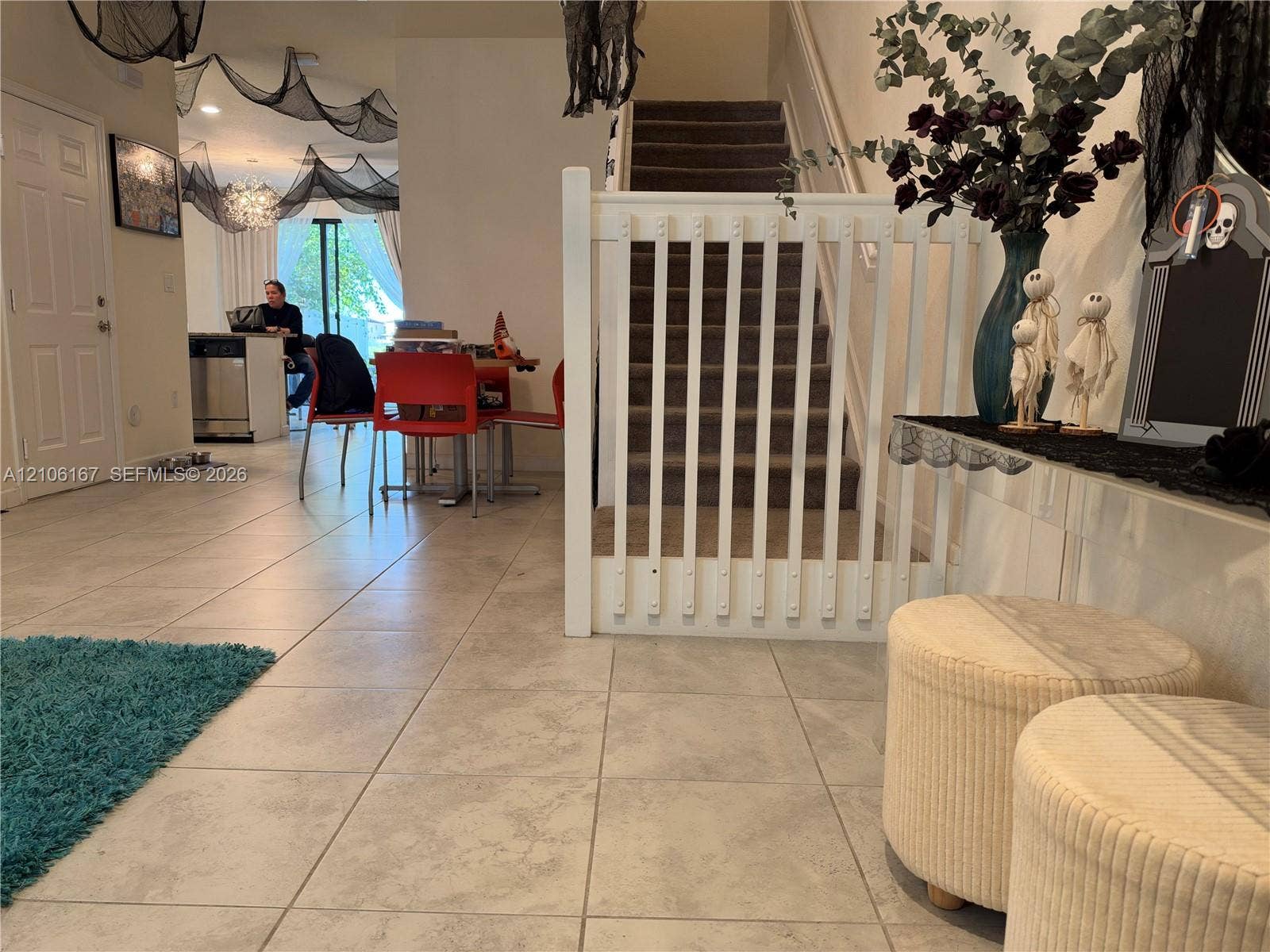 3277 W 100th Terrace, Hialeah, FL 33018 Neutral tile flooring throughout the common area, staircase with carpeted treads, and a white wooden balustrade