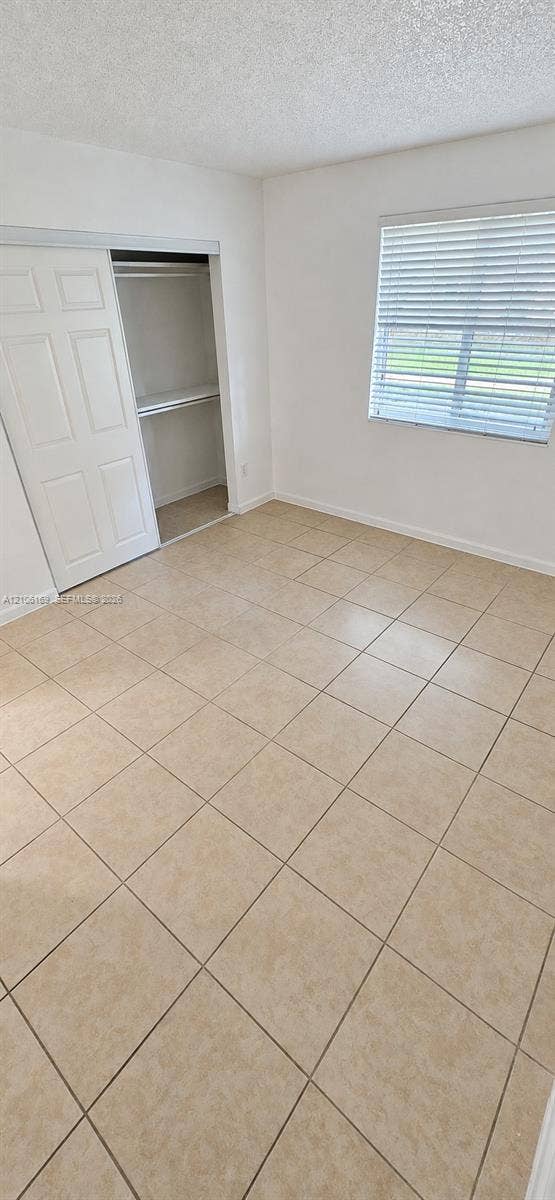 10820 SW 200th Drive, #162, Cutler Bay, Cutler Bay, FL 33157 Room featuring neutral-toned tile flooring, light-colored walls, sliding closet doors, and a window with horizontal blinds