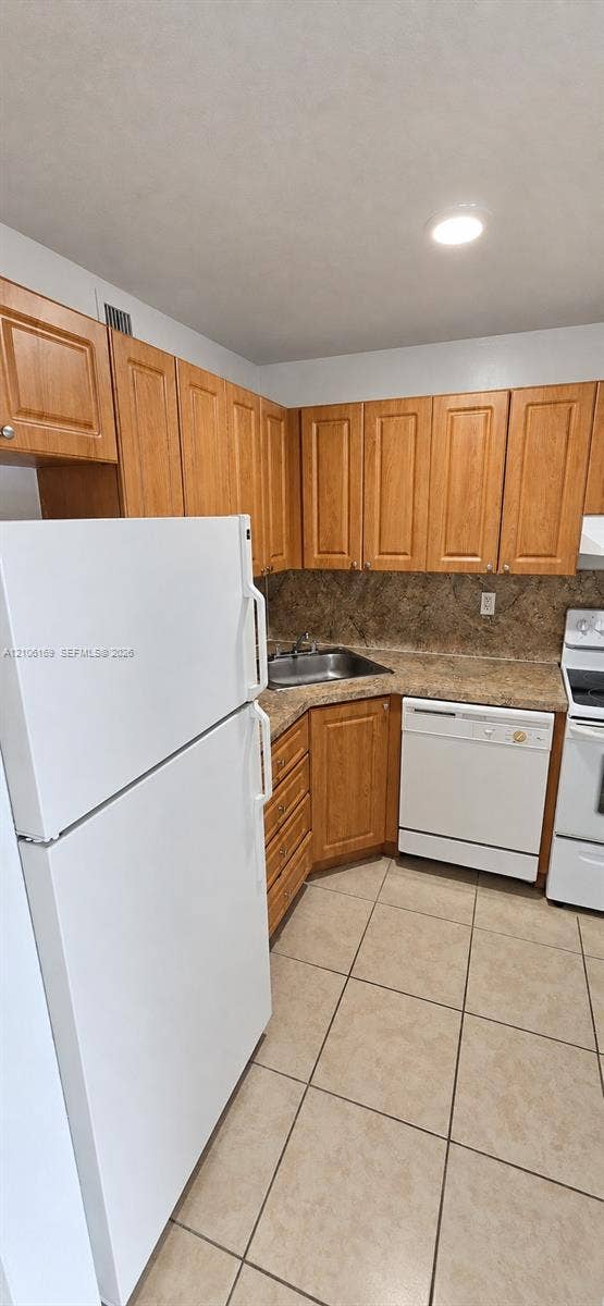 10820 SW 200th Drive, #162, Cutler Bay, Cutler Bay, FL 33157 Kitchen featuring light-tone wood cabinetry, stone-finish countertops, tile flooring, and white appliances