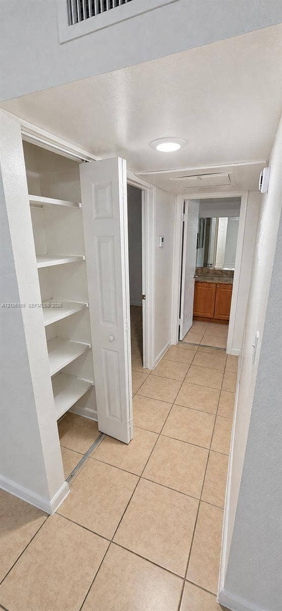 10820 SW 200th Drive, #162, Cutler Bay, Cutler Bay, FL 33157 Hallway featuring tile flooring, built-in storage shelving with folding doors, and recessed lighting