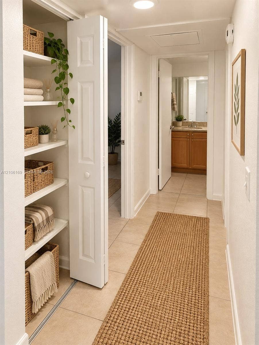 10820 SW 200th Drive, #162, Cutler Bay, Cutler Bay, FL 33157 Built-in hallway storage featuring five open shelves, neutral tile flooring, and a paneled bi-fold door