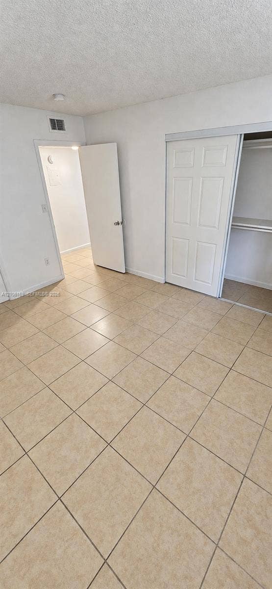 10820 SW 200th Drive, #162, Cutler Bay, Cutler Bay, FL 33157 Neutral tile flooring throughout, featuring a multi-panel sliding closet door and a six-panel interior swing door