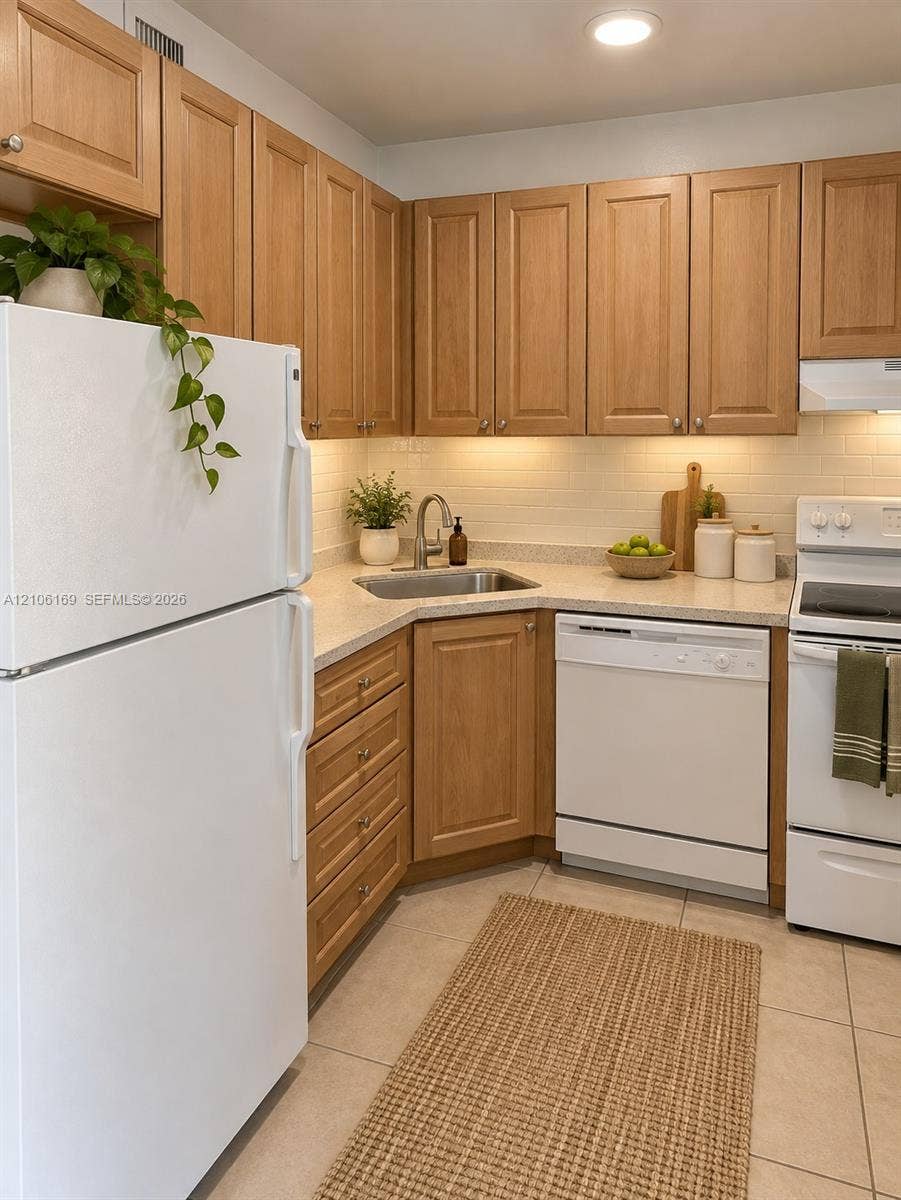 10820 SW 200th Drive, #162, Cutler Bay, Cutler Bay, FL 33157 Kitchen featuring shaker-style wood cabinetry, light-toned countertops, subway tile backsplash, stainless steel sink, and tile flooring